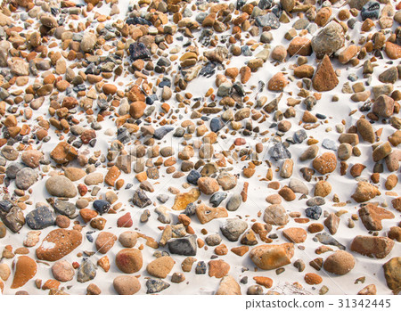 smooth round pebble stones on the sand backgound. smooth round pebble stones on the sand backgound. 31342445