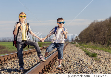 Happy brother and sister walking on the railway at the day time. 31342449