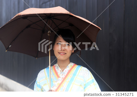 Summer image A young lady in a yukata standing at a parasol 31345271