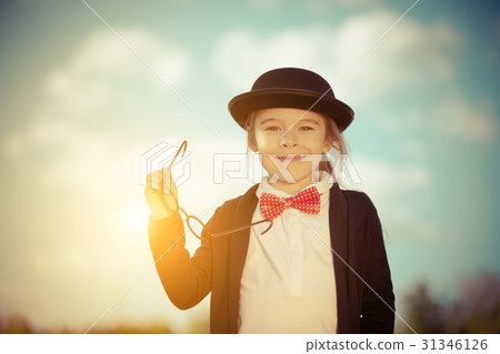 Funny little girl in bow tie and bowler hat. 31346126