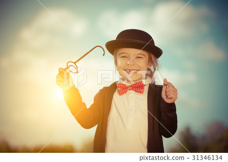 Funny little girl in bow tie and bowler hat. 31346134