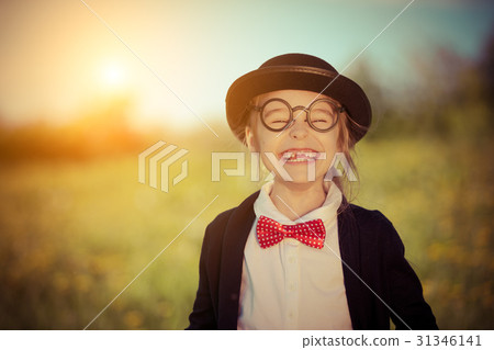 Funny happy little girl in bow tie and bowler hat. 31346141