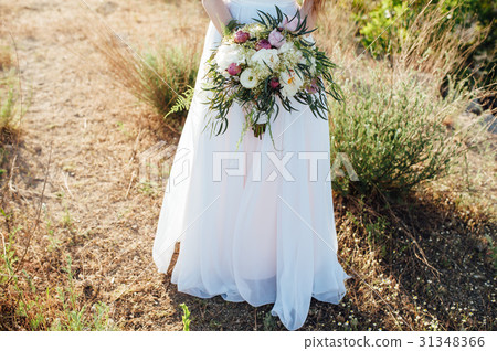 bride in a white dress holding a bouquet 31348366