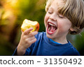 cute blonde child about to take a bite of an apple 31350492