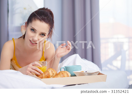 Young beautiful woman having breakfast in bed. 31352421