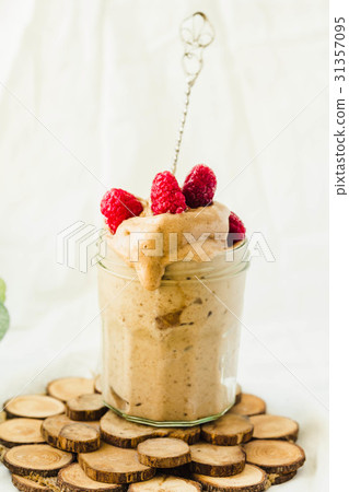Melts ice cream with raspberries in a glass jar. Melts ice cream with raspberries in a glass jar. 31357095