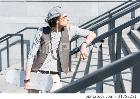Thoughtful teenager standing on steps outdoors 31358251