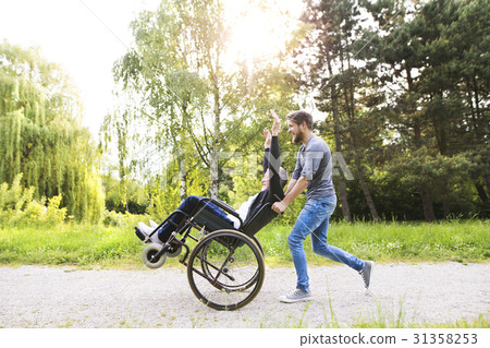 Hipster son running with disabled father in Hipster son running with disabled father in 31358253