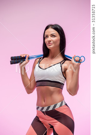 The woman training against pink studio with jump 31358715