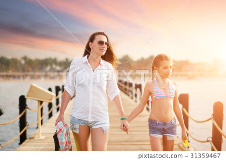 Young woman with her daughter strolling along pier Young woman with her daughter strolling along pier 31359467