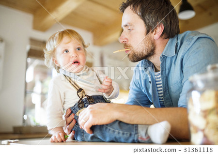 Young father at home with his little son eating Young father at home with his little son eating 31361118