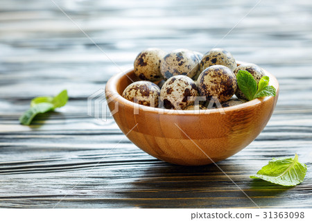 Wooden bowl with speckled quail eggs. 31363098
