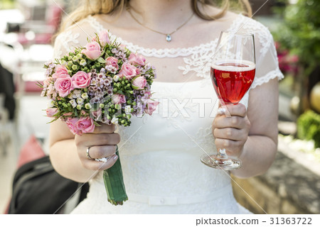 Bride holding bouquet of flowers and a glass of Bride holding bouquet of flowers and a glass of 31363722