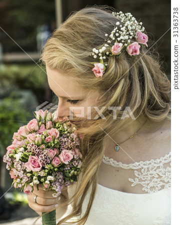 blonde bride inhale smell aroma of a flower 31363738