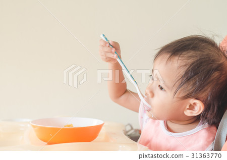 Asian toddler girl eating cereals with milk. Asian toddler girl eating cereals with milk. 31363770