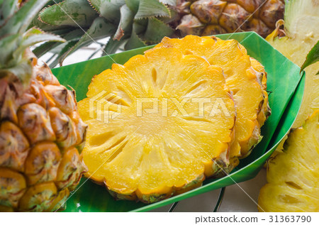 Fresh pineapple with slices on the wood background Fresh pineapple with slices on the wood background 31363790