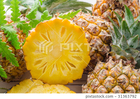 Fresh pineapple with slices on the wood background Fresh pineapple with slices on the wood background 31363792