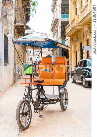 Cuban taxi bicycle parked in front of colorful 31364604