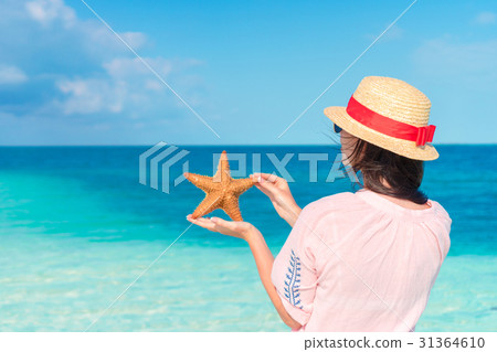 Young woman with starfish on white beach in the Young woman with starfish on white beach in the 31364610