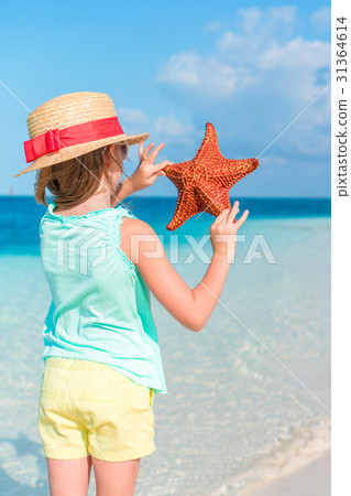 Adorable little girl holding giant red starfish on Adorable little girl holding giant red starfish on 31364614
