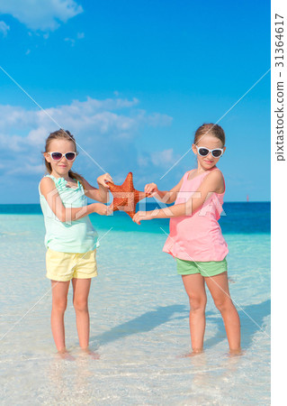 Adorable little girls with starfishes on white 31364617