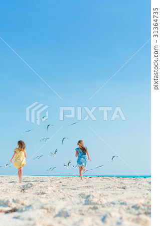Little girls having fun at tropical beach playing Little girls having fun at tropical beach playing 31364735