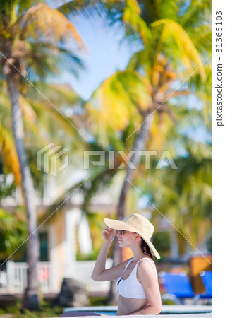 Beautiful young woman relaxing in swimming pool 31365103