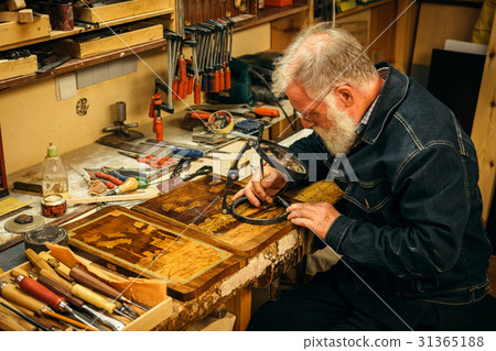Senior wood carving professional during work Senior wood carving professional during work 31365188