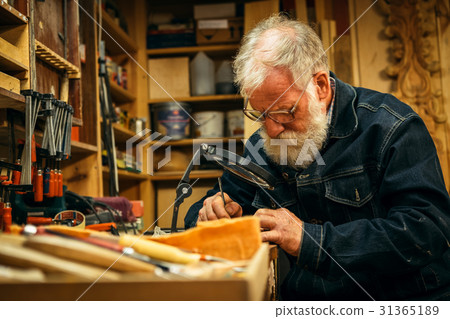 Senior wood carving professional during work Senior wood carving professional during work 31365189
