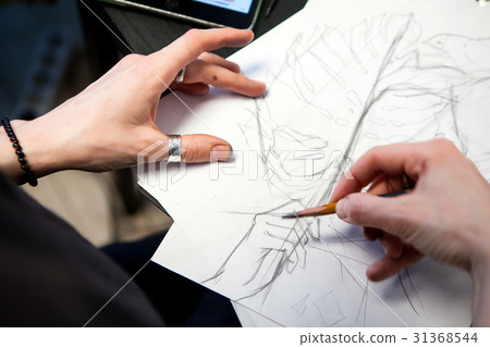 Girl tattoo artist draws a sketch. Close-up of 31368544