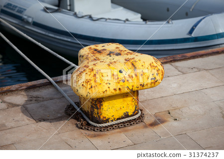 Old yellow bollard in the port Old yellow bollard in the port 31374237