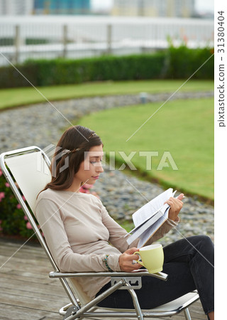 Enjoyng a book 31380404