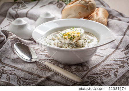Sorrel soup with egg in white bowl. 31381674