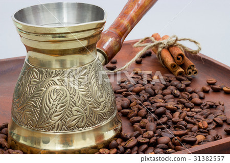 Copper coffee pot with coffee beans and cinnamon Copper coffee pot with coffee beans and cinnamon 31382557