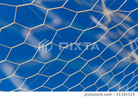white soccer, or football, net with blue sky 31385329