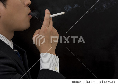 A businessman smoking a cigarette 31386083