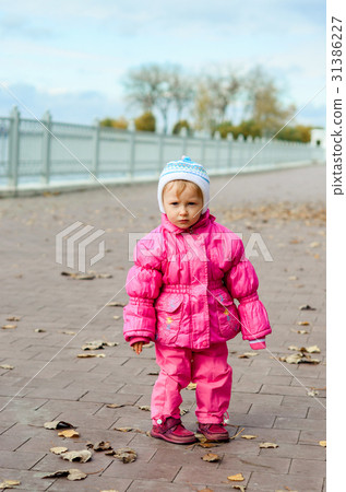 girl in a jacket standing near the waterfront 31386227