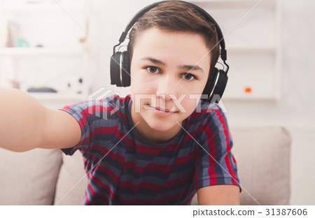 Boy in headphones taking selfie at home Boy in headphones taking selfie at home 31387606