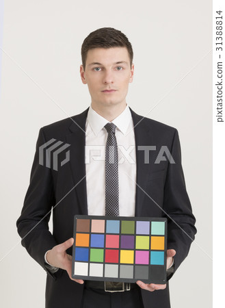 Young photographer holding color checker card Young photographer holding color checker card 31388814