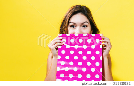 Happy young woman holding a shopping bag Happy young woman holding a shopping bag 31388921