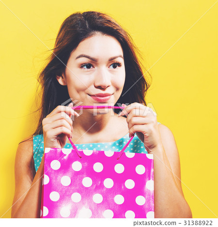 Happy young woman holding a shopping bag Happy young woman holding a shopping bag 31388922