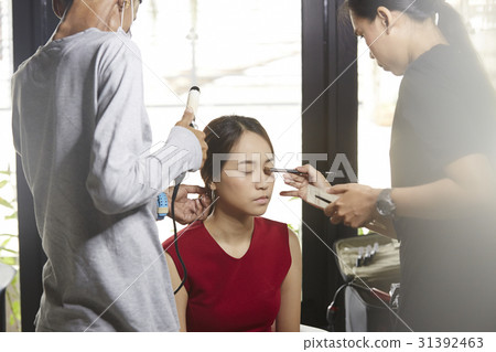 stylists are making up for a female model. 31392463