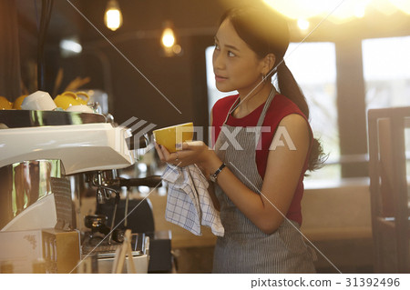 a woman looks outside when cleaning a cup. a woman looks outside when cleaning a cup. 31392496
