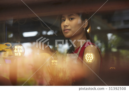 a picture of a woman standing behind a glass. 31392508