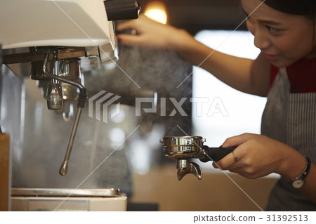 a barista is using coffee machine to make a cup of coffee. a barista is using coffee machine to make a cup of coffee. 31392513