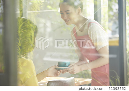 a waitress is bringing a cup of coffee for the customer. 31392562