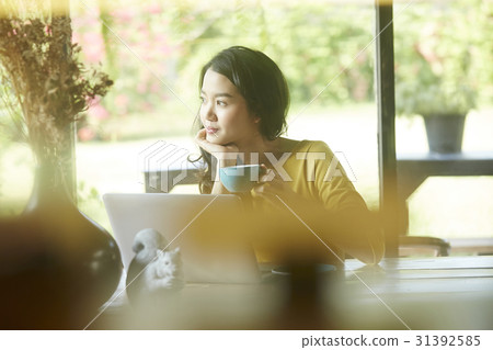 Young woman is dreaming about something and holding a cup of tea. Young woman is dreaming about something and holding a cup of tea. 31392585