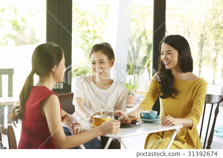 Three beautiful girls are having a coffee break, talking, laughing. 31392674