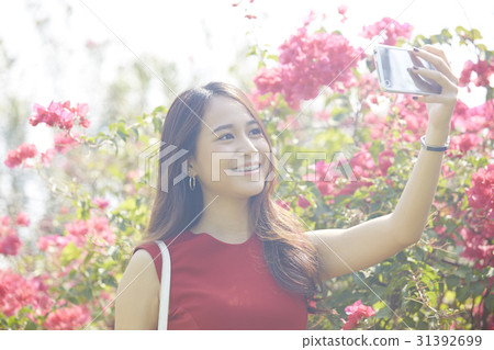 Young woman is taking selfie in a beautiful garden 31392699