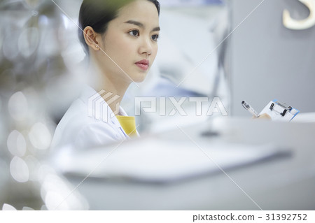 An image of a young doctor looking at something. 31392752